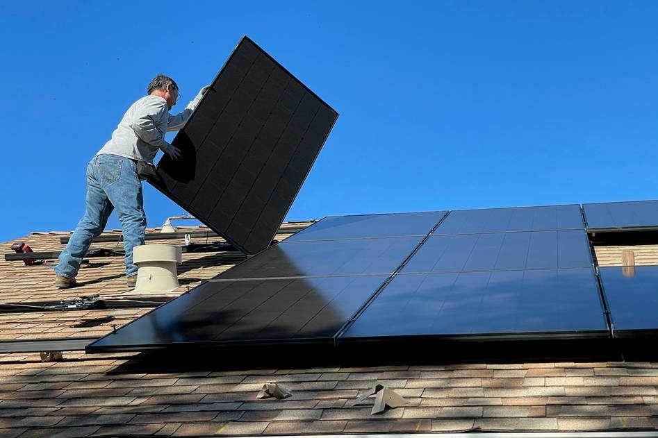 Hands installing UV-resistant solar cables between rooftop panels with tools nearby